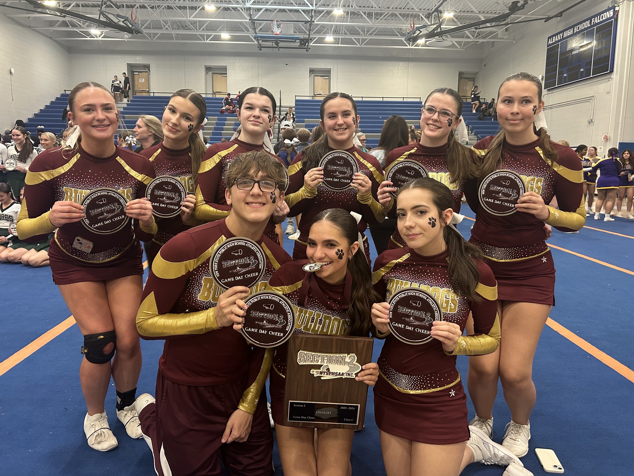 students standing posing for cheerleading championship with awards for pic