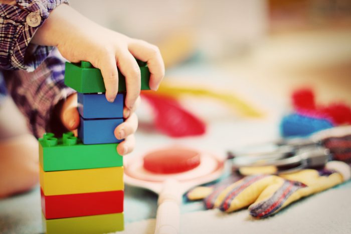 picture of a child's hand working with oversized legos