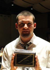 Neale Dunston stands with his Outstanding Student Award for Welding II