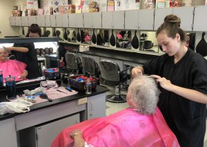 girl cutting woman's hair