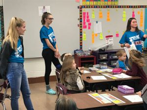 three high school girls in an elementary classroom