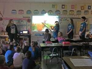 student pointing at a picture on a whiteboard in an elementary class room.