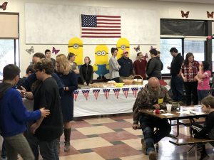 food table beneath U.S. flag staffed by students