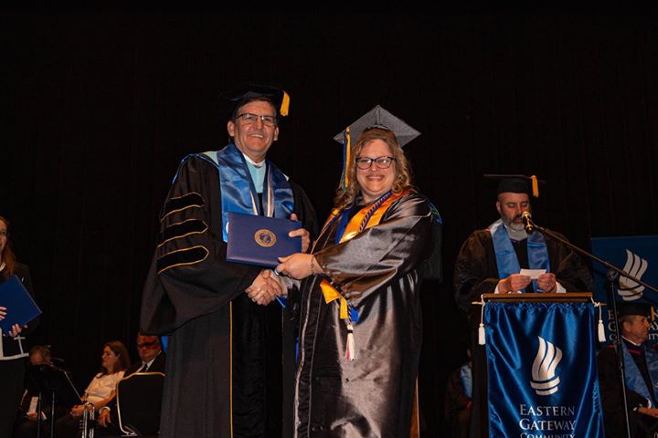 woman is presented her college diploma