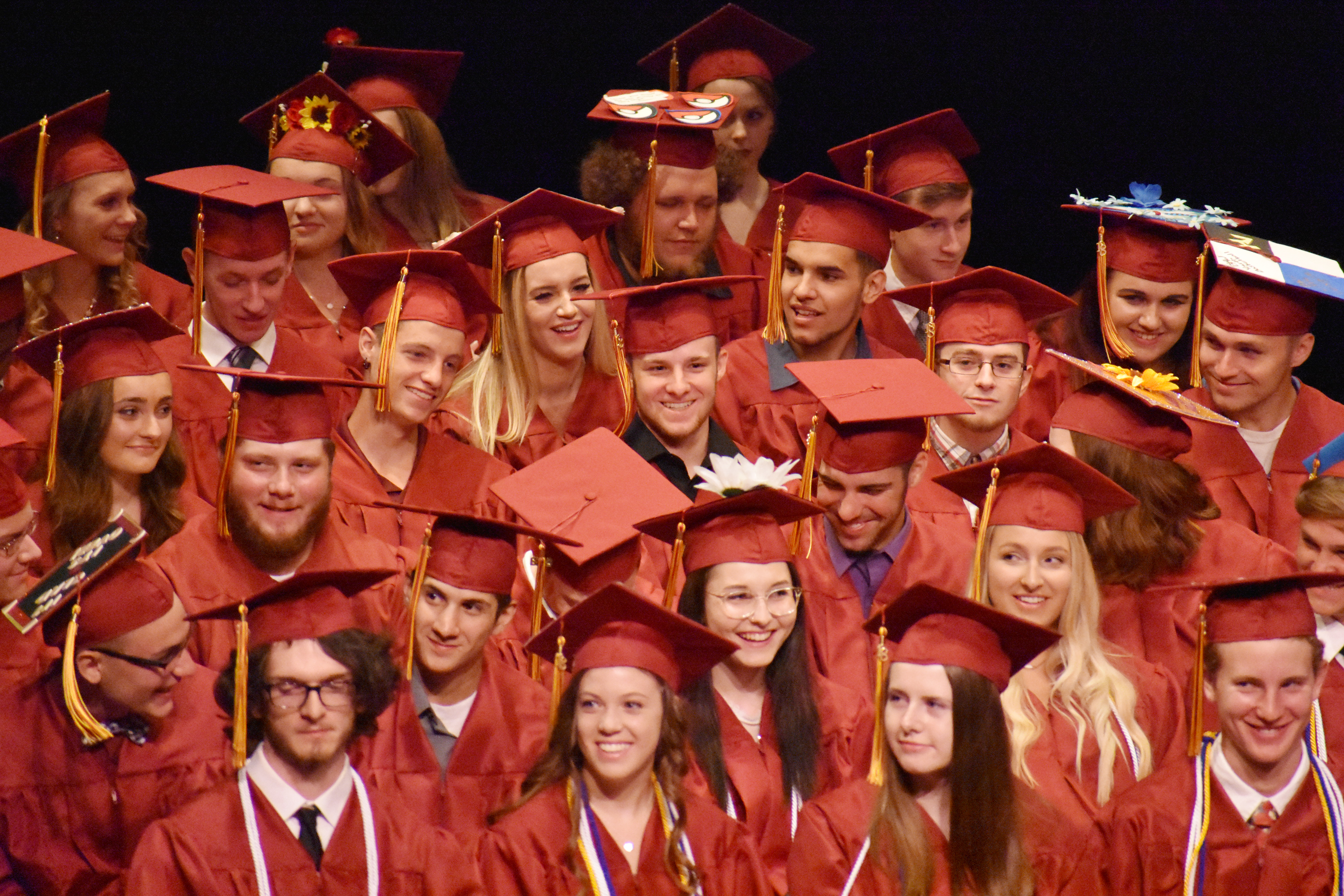 large group of graduates in their red caps and gowns