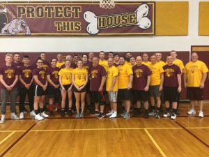 basketball team poses in yellow t shirts