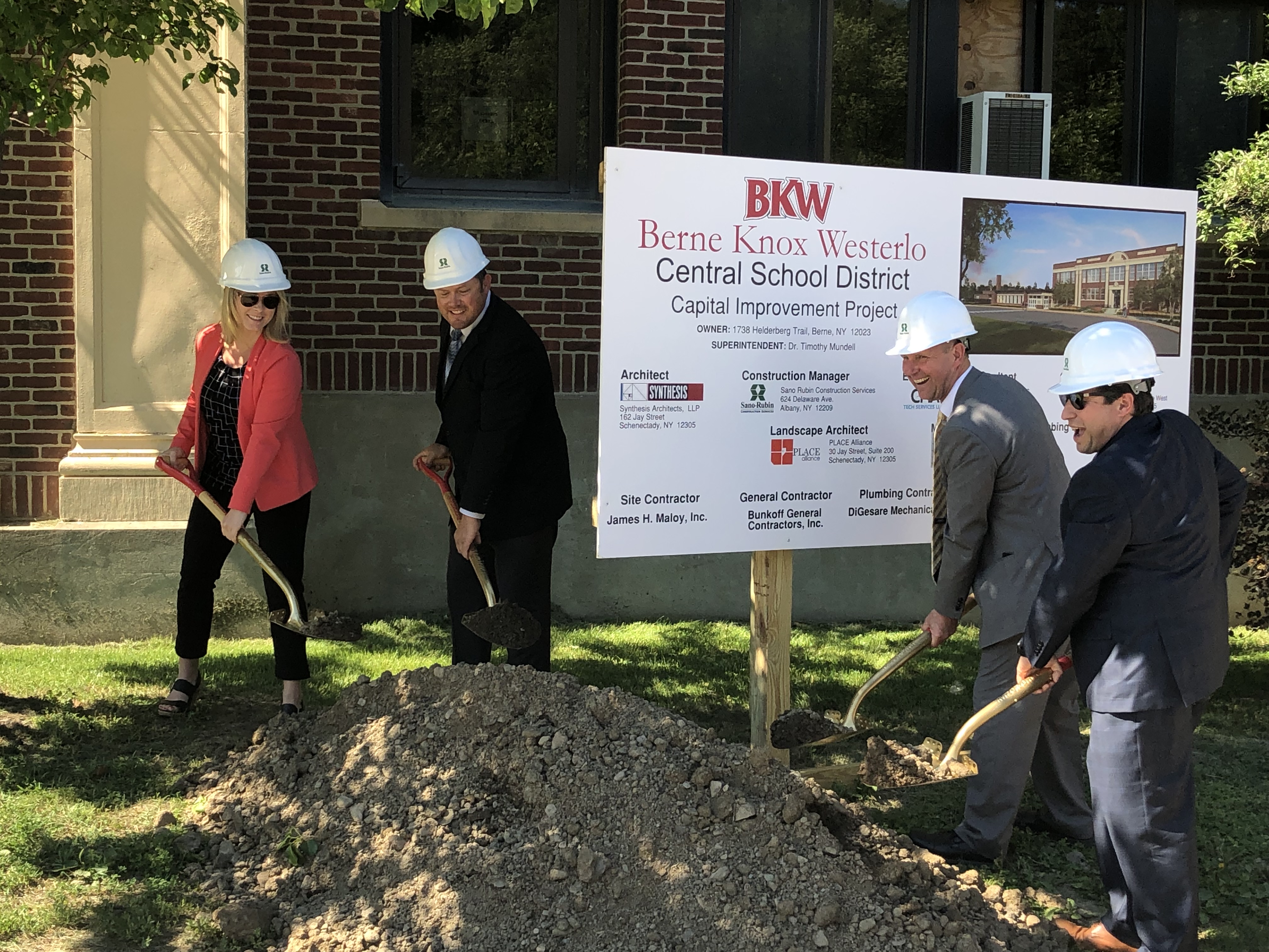 four people put ceremonial shovels in the ground