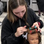 girl put rollers in doll hair