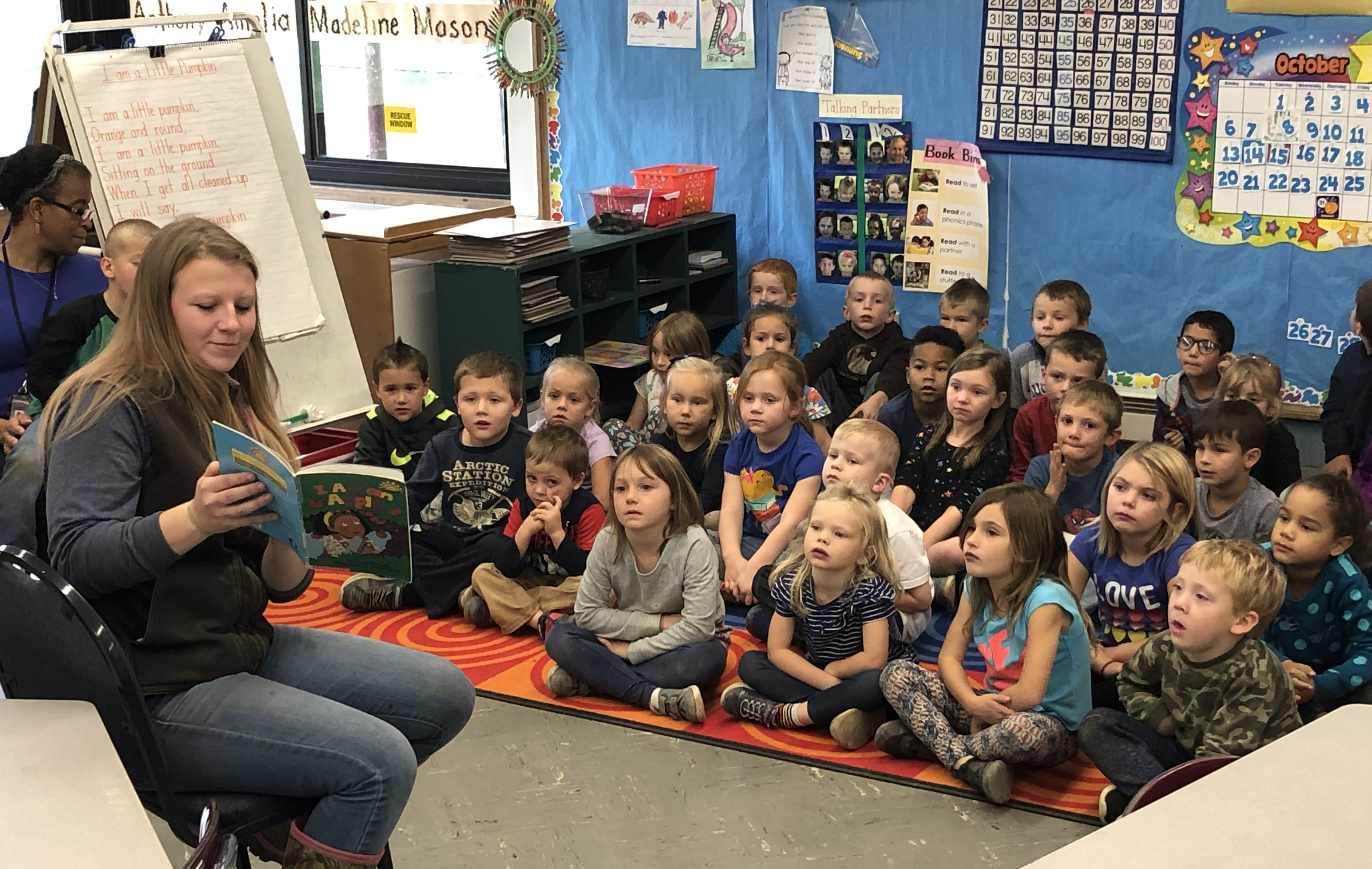 girl reads to kindergarten class