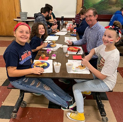 elementary students eating with vets at a table