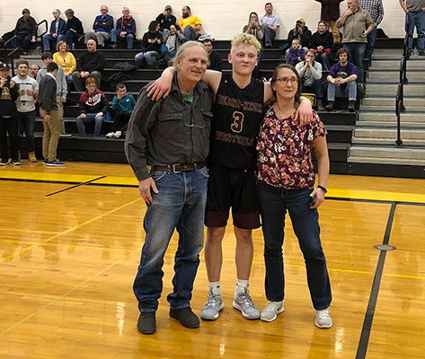 Zeke Pulliam stands with his parent s on the court