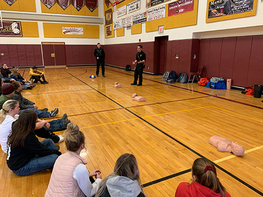 students sit and learn about CPR