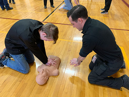 student performs CPR as Shift Supervisor Barach offers guidance