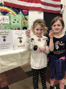 two girl hold their beet cups