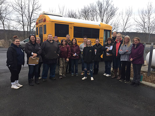 BKW staff pose in front of bus before heading out to deliver meals for students