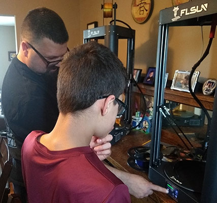 Joaquin's dad instructs him at the printer