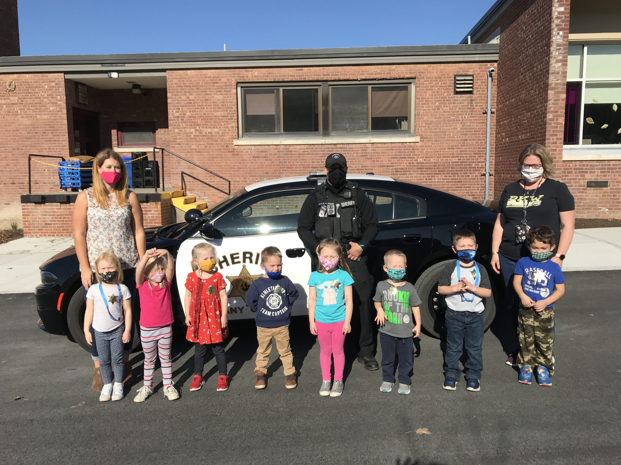 group of kids and sheriff outside his police car