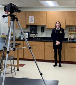 student presenting in front of video camera