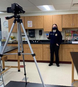 student presenting in front of video camera