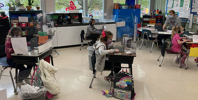 students and teacher sitting at their computers