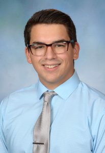 boy in blue shirt, tie and glasses