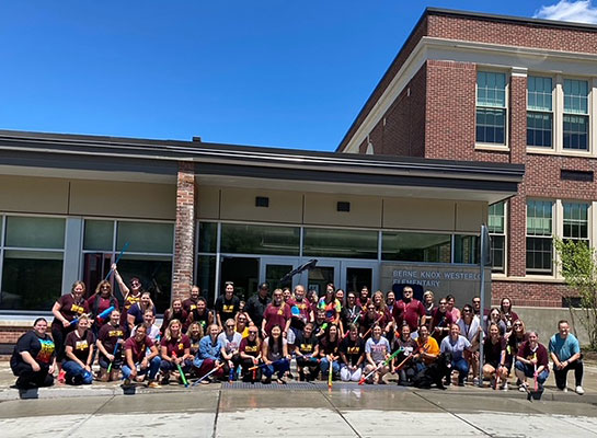 Group of teachers and staff in front of school