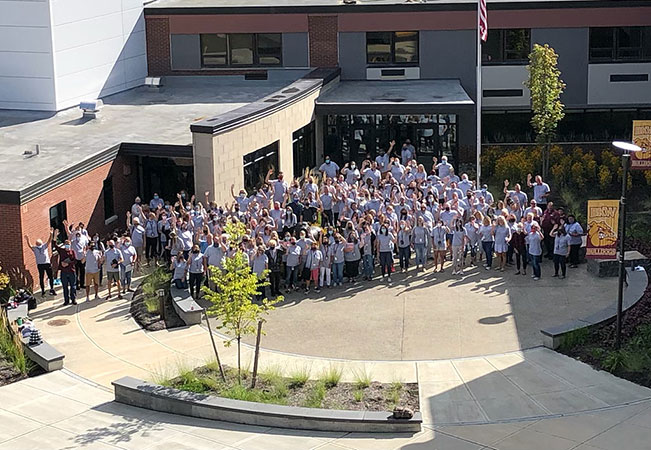 BKW faculty and staff standing as a group outside school building