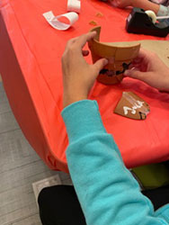 a student's hands putting together a pot