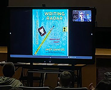 Jack Gantos and image that says Writing Radar on video screen in front of seated students