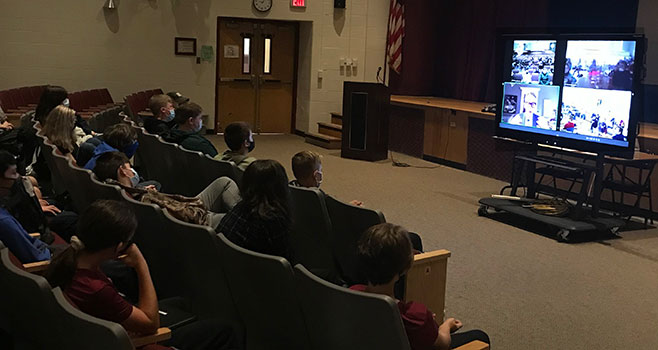 Jack Gantos and images on video screen in front of seated students