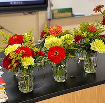 a group of floral arrangements - flowers in mason jars