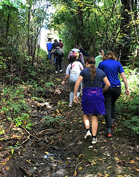 students hiking up a trail