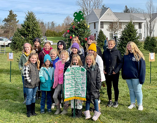 students standing in front of decorated tree