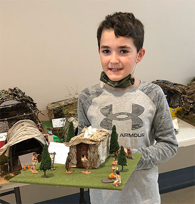 student holding their longhouse project