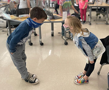 2 students bowing to each other