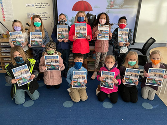 students holding coloring books