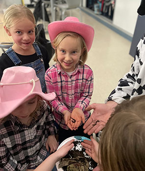 student holding earthworms