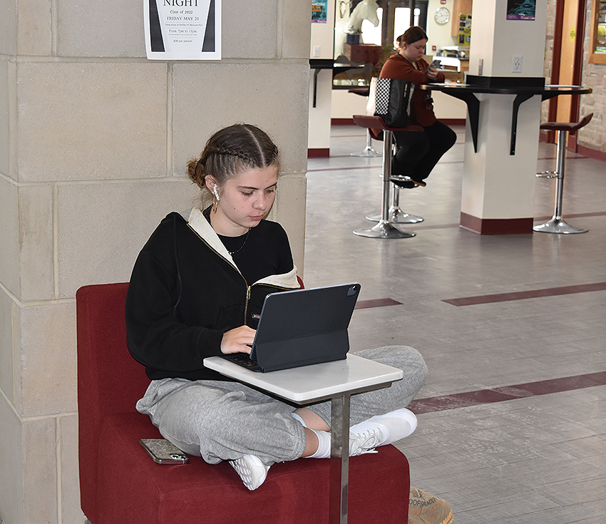 student seated working on their laptop