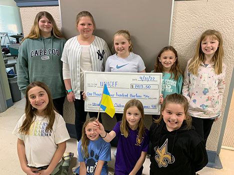 students pose with big check