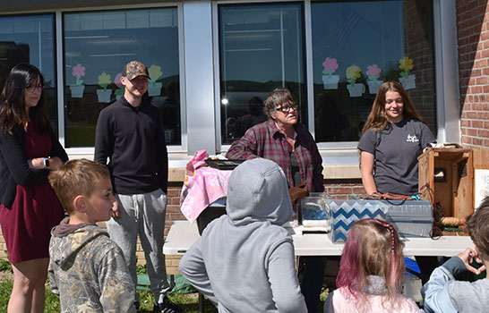 Wildlife rehabilitators and student interns at table talking to students