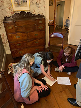 students sitting on floor looking at paper