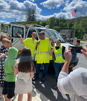 people holding up reflective vests in front of a truck