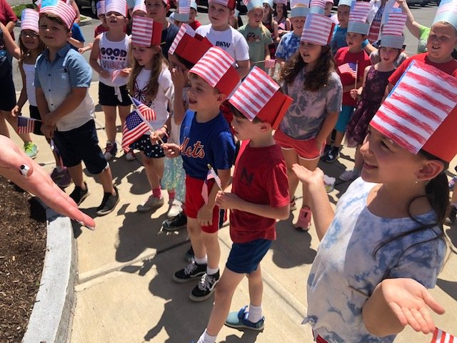 kids in flag hats waving flags