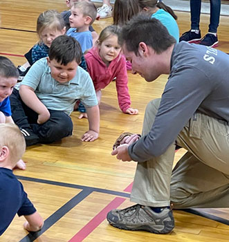 zoo mobile person showing an animal to students