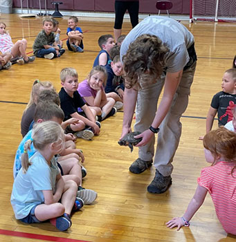 zoo mobile person showing an animal to students