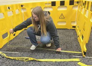 Berne-Knox-Westerlo High School senior Kaylee Duncan taking measurements of a “crime scene” on the Capital Region BOCES Career & Technical Education enter – Schoharie Campus.