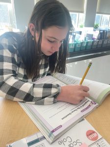An elementary student diving into her school work as part of the Welcome to Magnetic Reading curriculum.