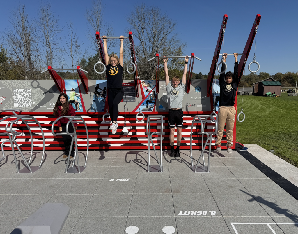 BKW students put the new Fitness Center in Berne's town park to the test. From left are: cheerleader Emma Detlefsen; basketball player Bella Daguillo; Patrick Lendrum, who participates in cross-country, basketball, and track; and Aggelos Lefkaditis, who is on the soccer and track teams. Photo credit - The Enterprise — Michael Koff.