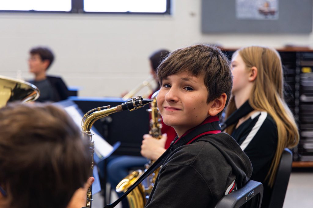 young student with instrument looking up at camera