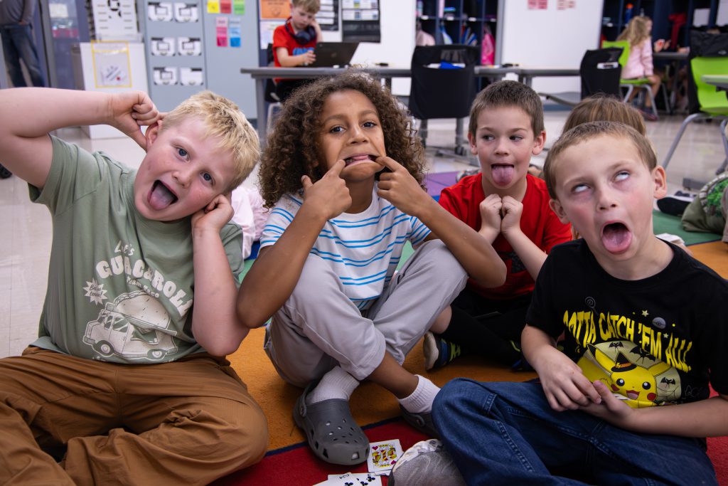four young students having fun making faces posing for the camera